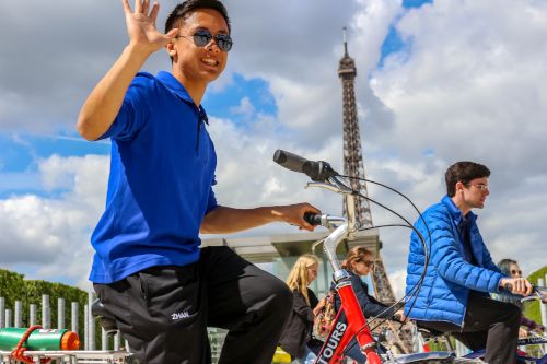 Haolan biking in front of Eiffel Tower on French Exchange with his classmates.