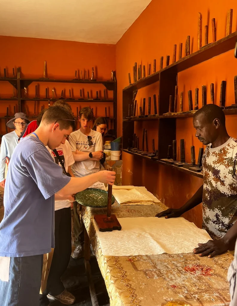 Student participating in a hands-on batik workshop during a Senegal educational tour