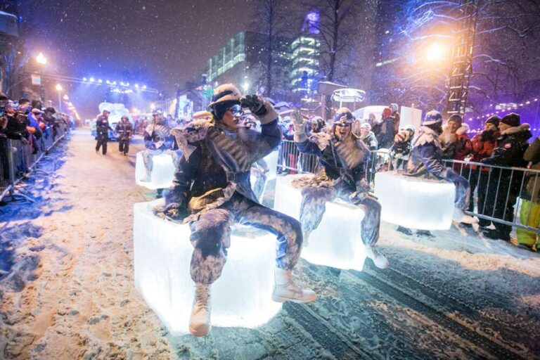 Performers on illuminated ice-block floats during the Québec Winter Carnival night parade